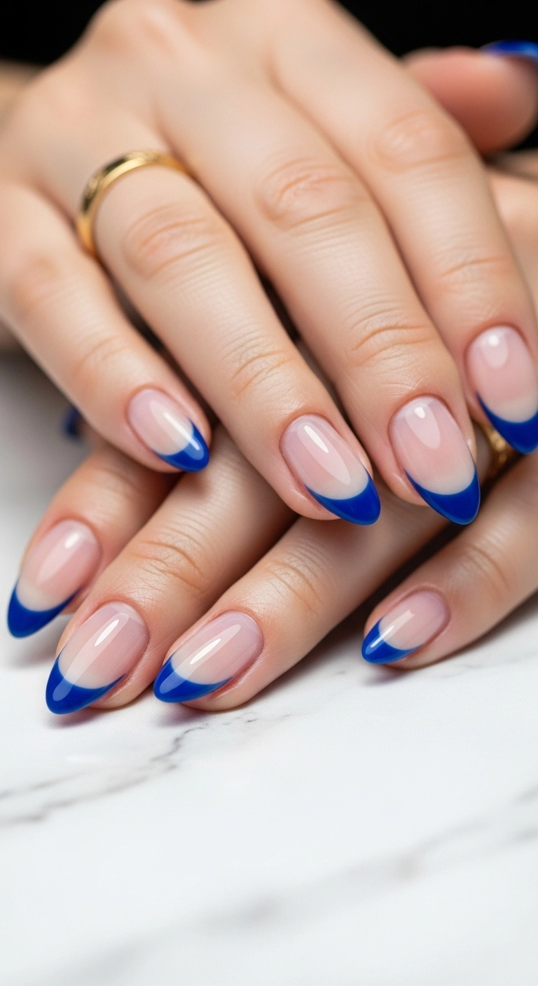 A minimalist and modern manicure featuring a thin colored outline around the tip of the nail, leaving the center bare for a negative space effect.