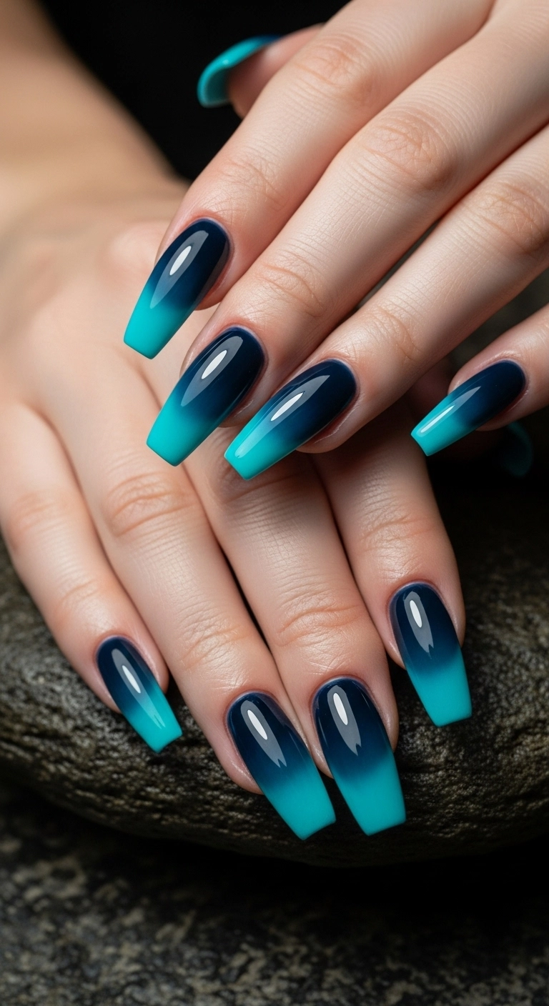 Long coffin nails with a dramatic deep ocean ombré French tip, fading from navy to turquoise.
