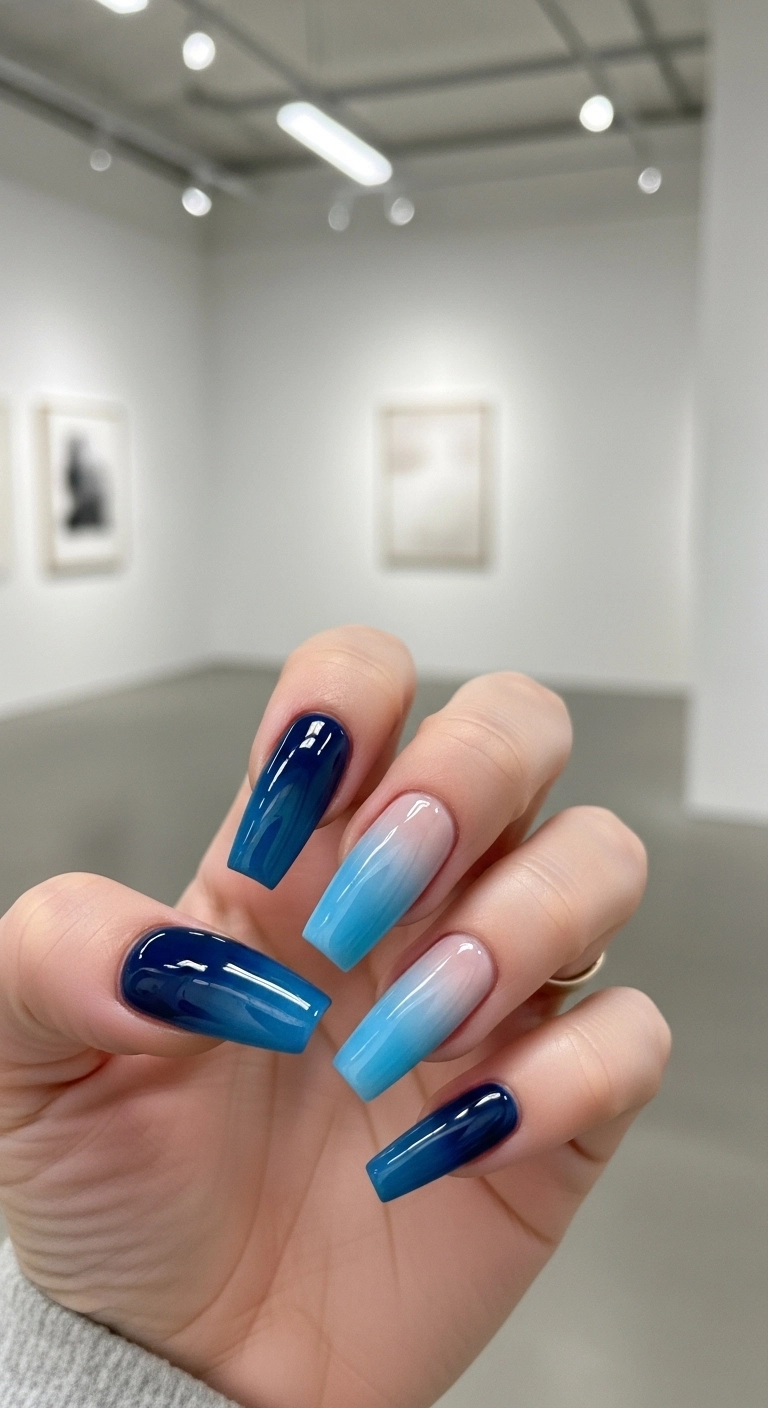 Close-up of long coffin nails with a beautiful blue ombré gradient effect.