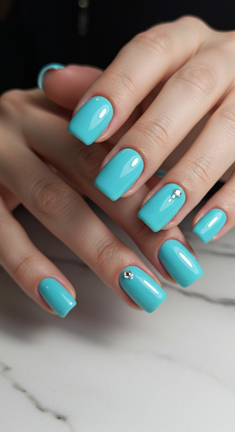 Elegant square nails painted in glossy Tiffany blue with a single rhinestone accent.