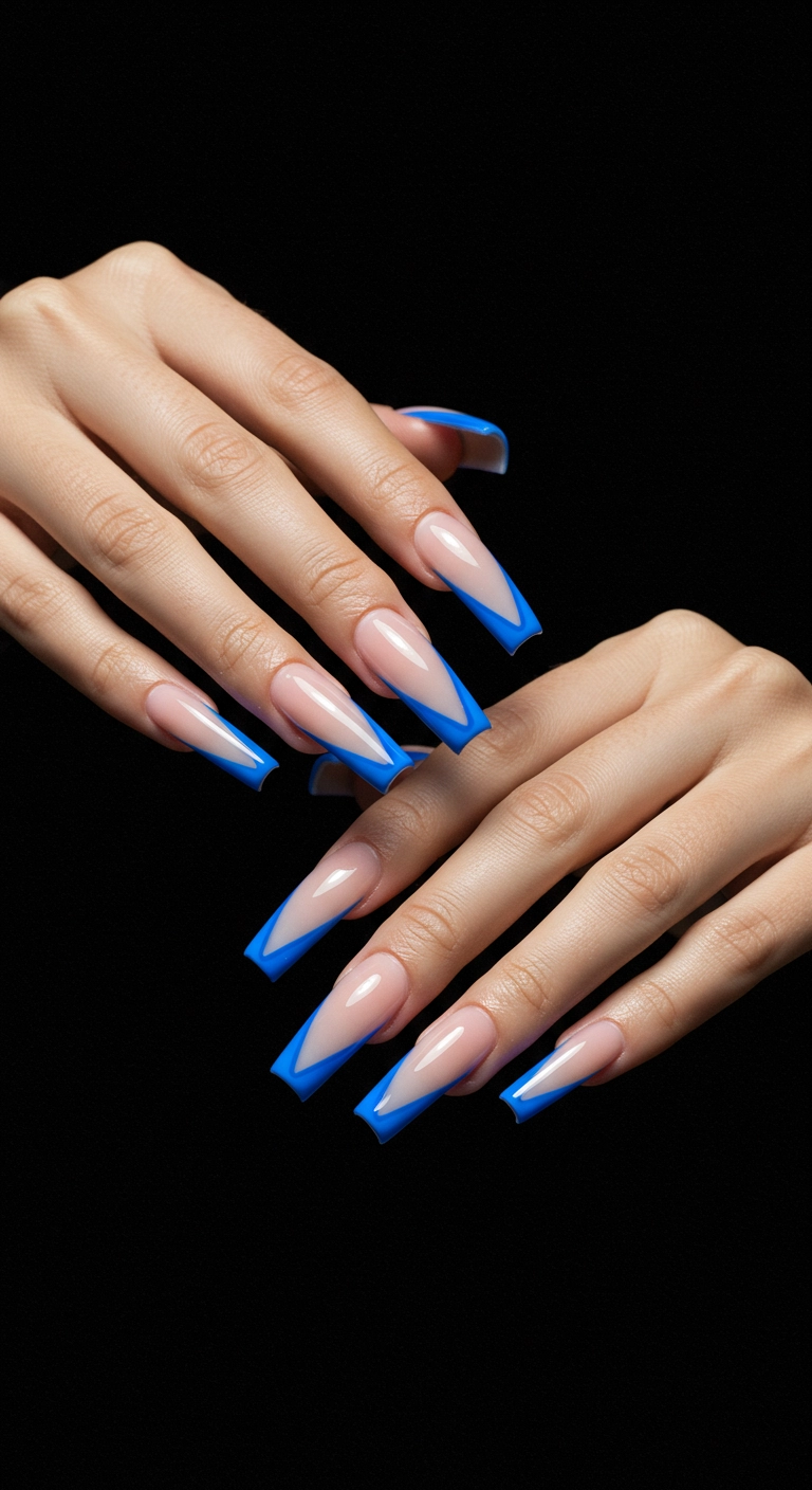 Long coffin nails with a sharp, edgy, electric blue V-shaped French tip design.