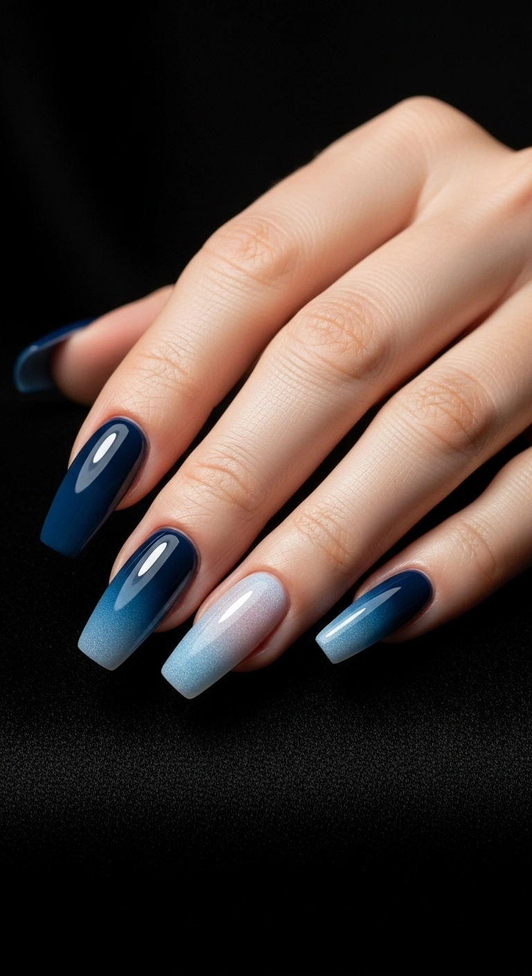 Long ballerina-shaped nails with a smooth color gradient from dark navy to light blue.