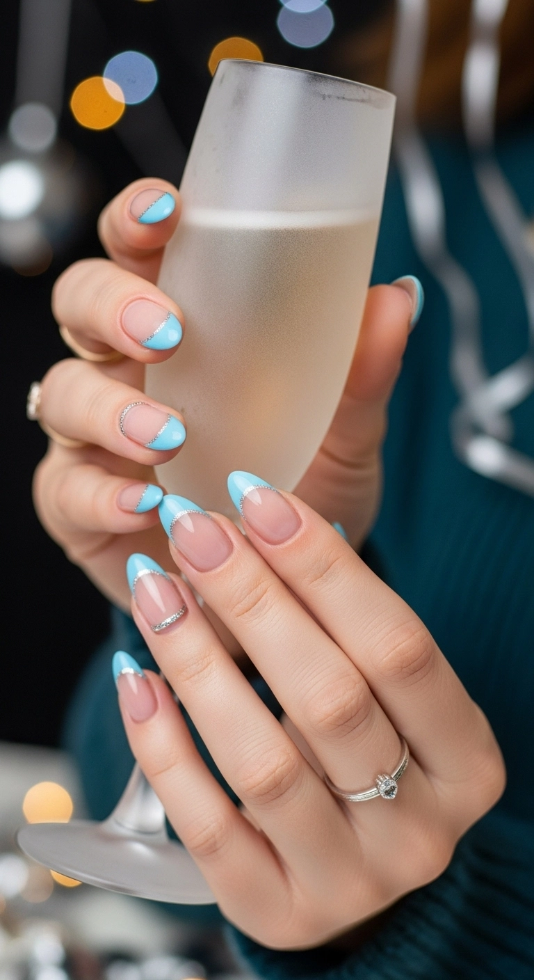 Almond-shaped nails with sky blue French tips and a delicate silver glitter line accent.
