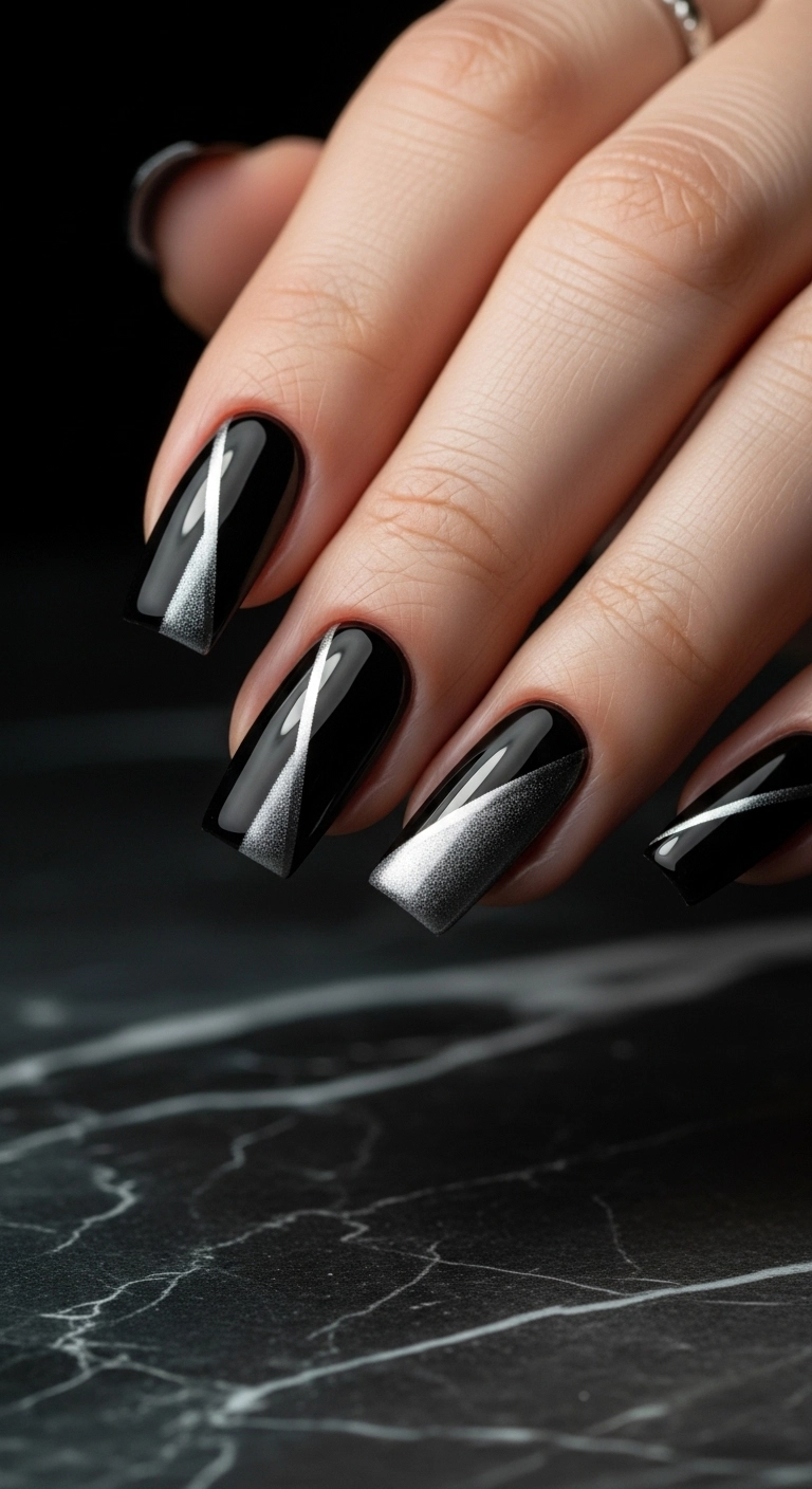 Glossy black square nails with a sharp and futuristic silver cat eye streak.