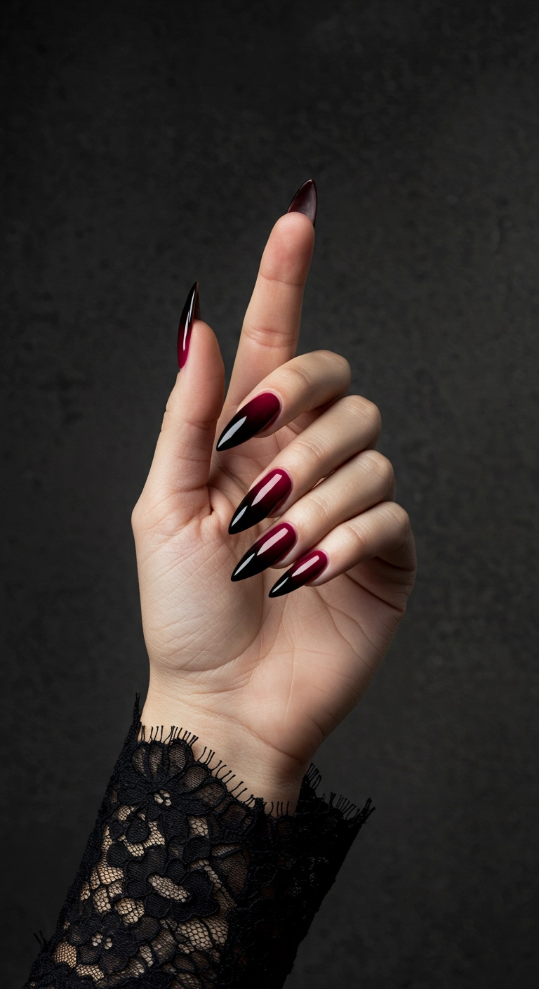 A dramatic black to deep burgundy ombré on long stiletto nails.