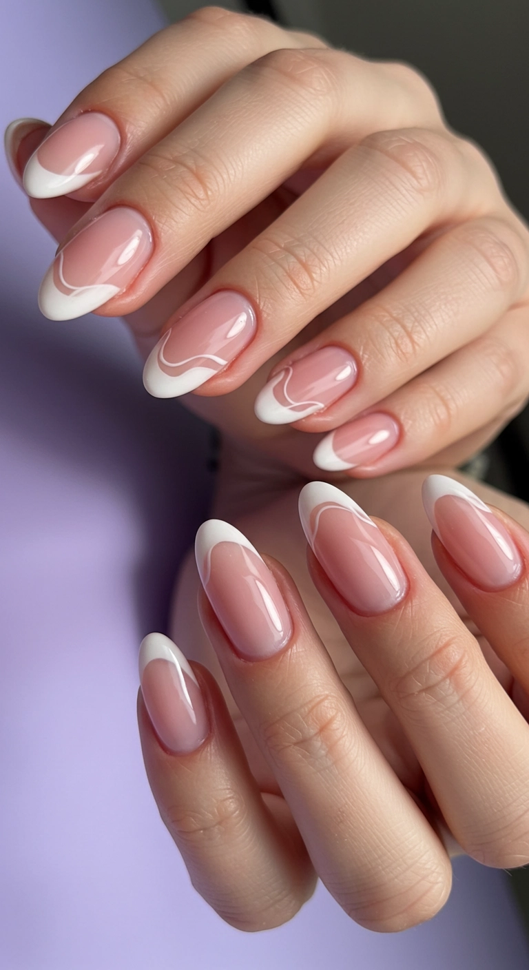 Almond nails with pastel pink French tips and delicate white swirls.