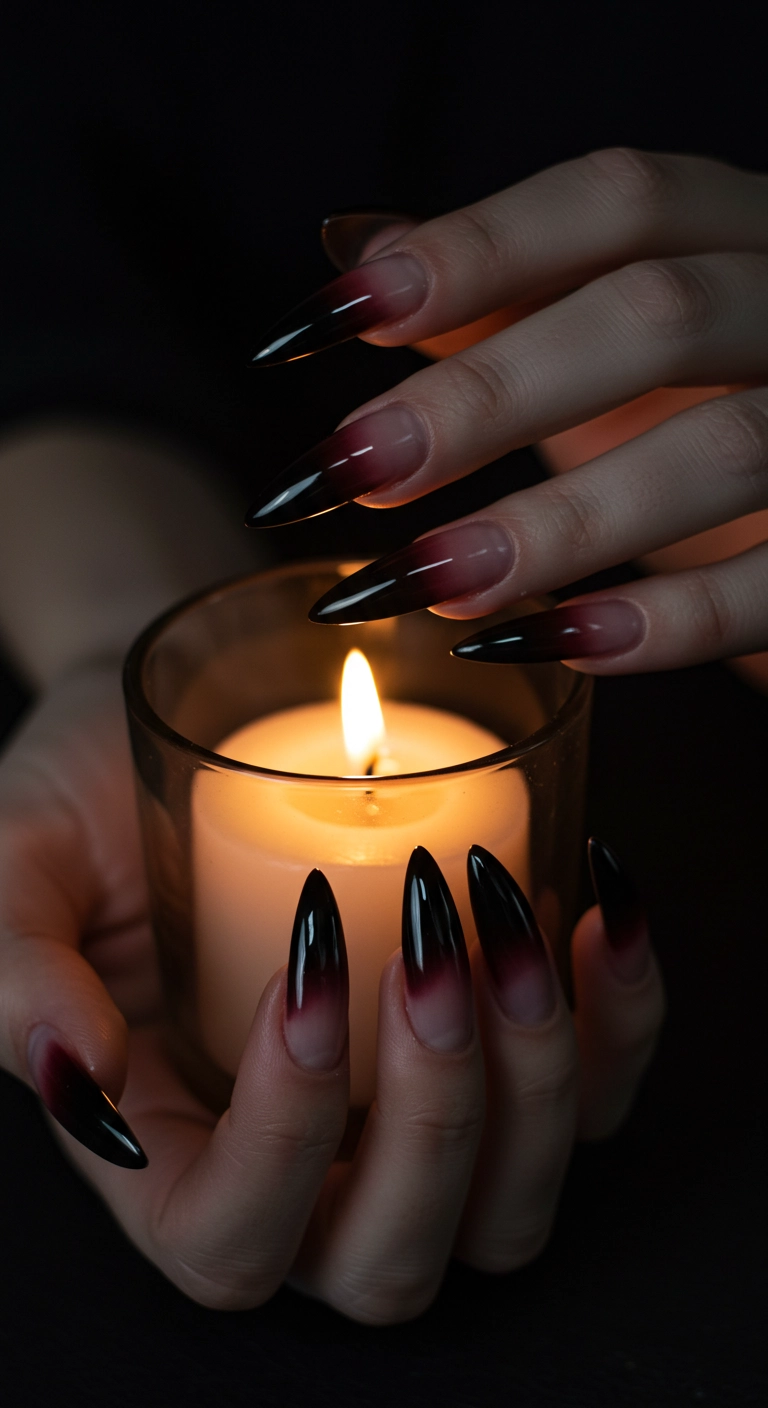 Long stiletto nails with a French tip that fades from blood red to black in an ombré style.
