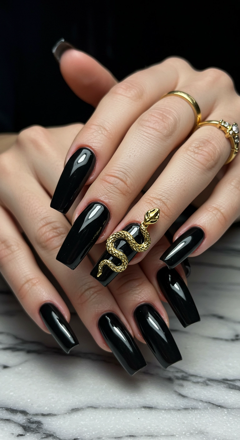 Glossy black coffin nails with a 3D gold snake charm on the ring finger.