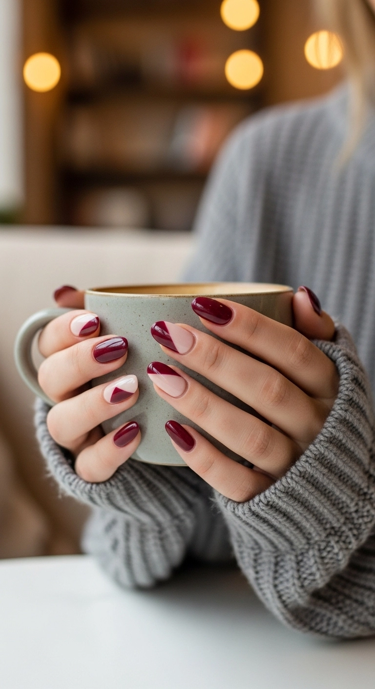 Squoval nails with a diagonal split of deep burgundy and soft cream.