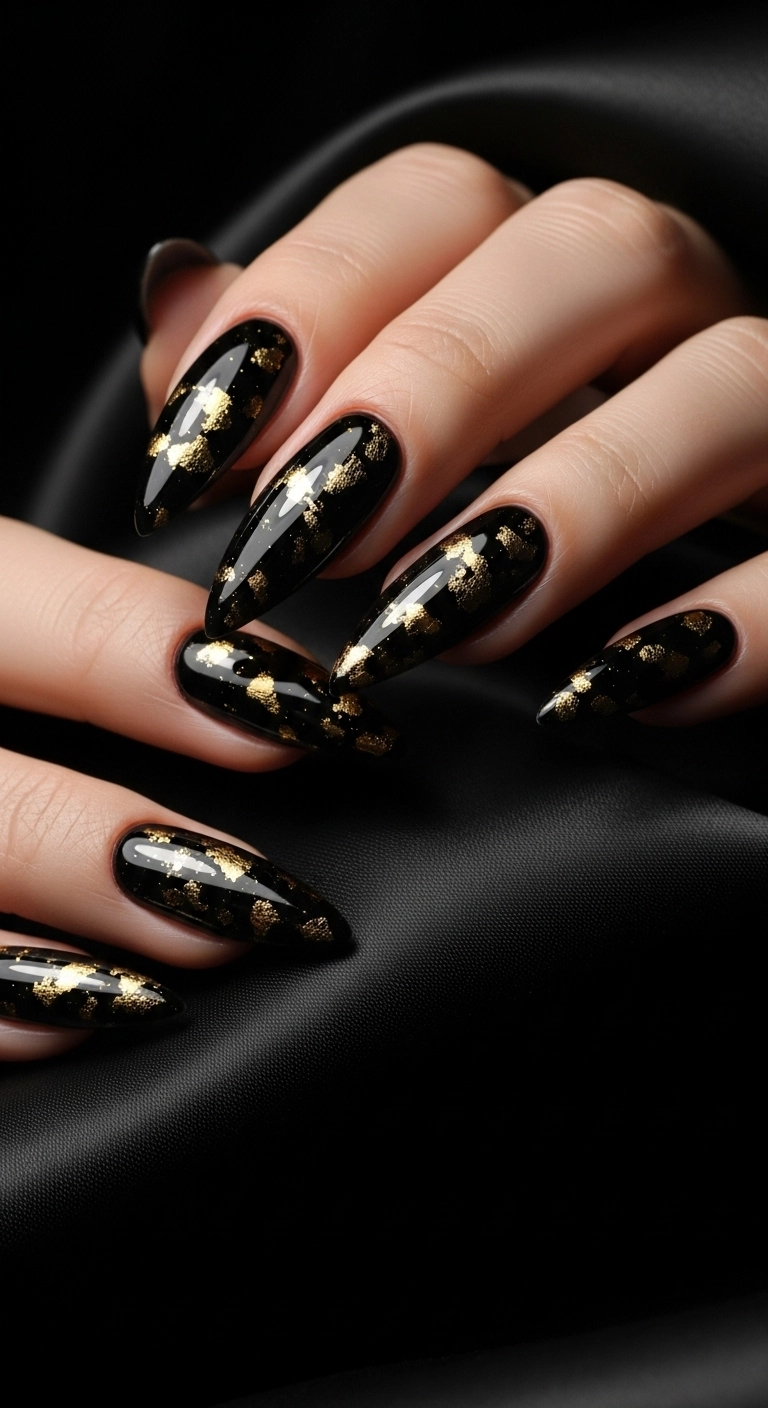 Stiletto nails with black chrome polish and gold flecks.