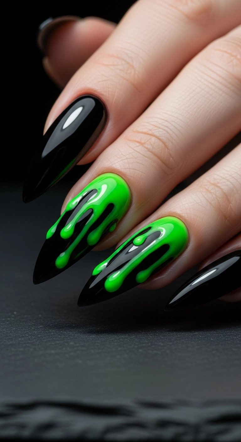 A close-up of stiletto nails with a black base and realistic neon green slime dripping down from the cuticles.