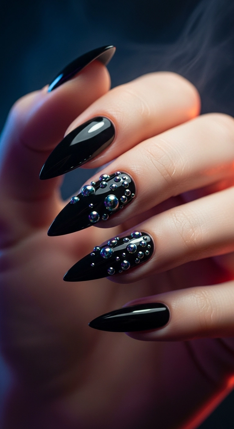 Black stiletto nails with iridescent 3D dots near the cuticle to look like cauldron bubbles.