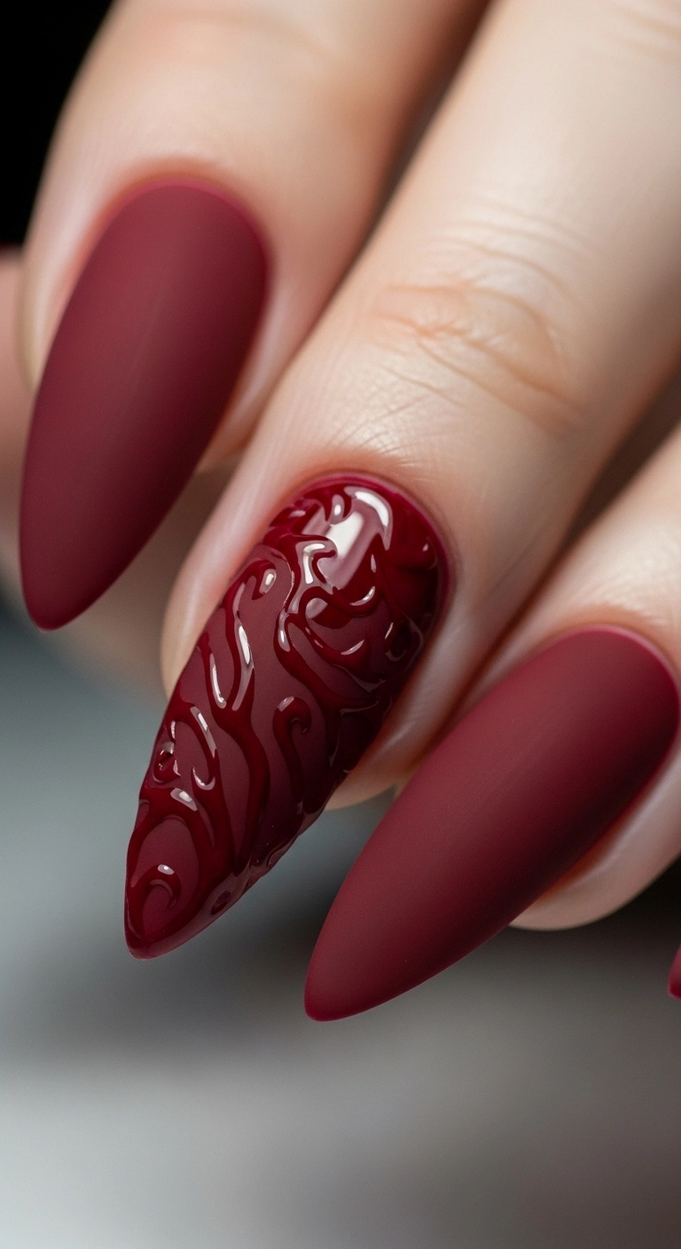 A matte red holiday nail with a glossy red design on top for a texture contrast.