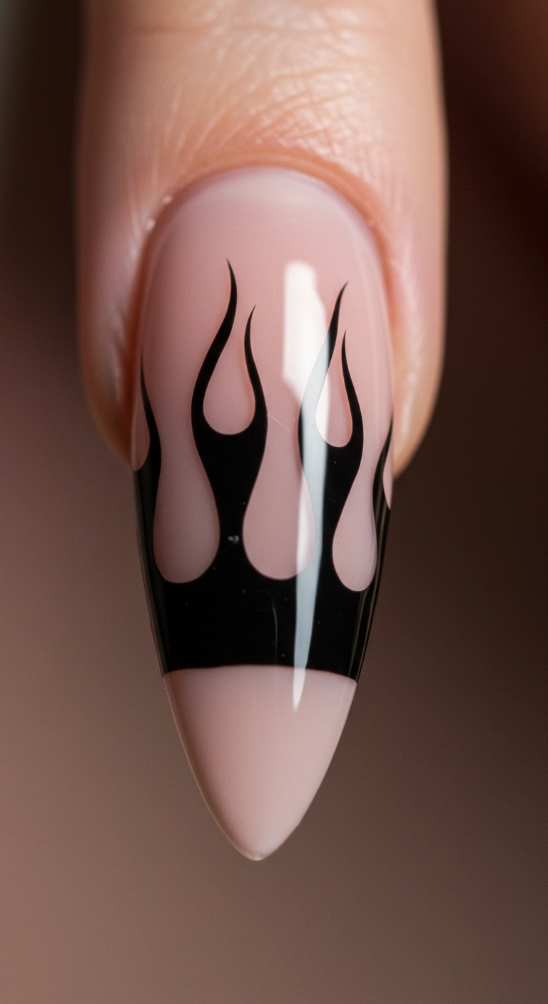 A macro shot of a nude almond nail with classic, high-gloss black flame art.